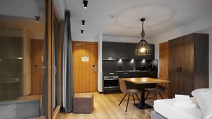 Una cocina moderna con armarios oscuros, una mesa de comedor de madera y una lámpara colgante.