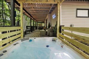 A wooden deck with a hot tub, outdoor furniture, and a covered area with a neon sign. - Poconos Chatham Continental - Hot Tub & Fire Pit (Bushkill)