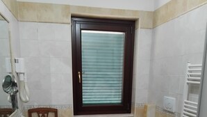 A bathroom with a sink, toilet, bidet, and window. - Alloggio Turistico (Fiumicino)
