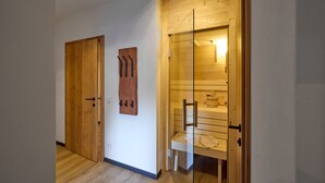 Un pasillo con puertas de madera, un banco y una obra de arte de madera colgada en la pared.