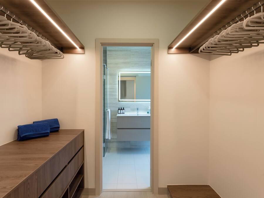 Un baño moderno con tocador de madera, un espejo y un perchero para toallas.