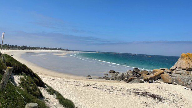 A beach with a clear sky, a sandy shore, and large rocks. - Maison 3 Bord de Mer, Chez Ty Suzanne à 150m des Plages de Sable fin (Cléder)
