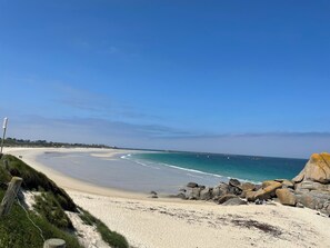 A beach with a clear sky, a sandy shore, and large rocks. - Maison 3 Bord de Mer, Chez Ty Suzanne à 150m des Plages de Sable fin (Cléder)