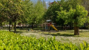 A park with playground equipment, benches, and trees. - The Turin Nest by Wonderful Italy (Turin)