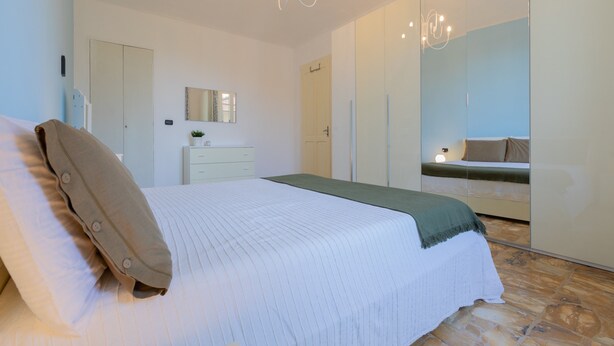 A bedroom with a bed, a dresser, a mirror, and a wardrobe. - The Turin Nest by Wonderful Italy (Turin)