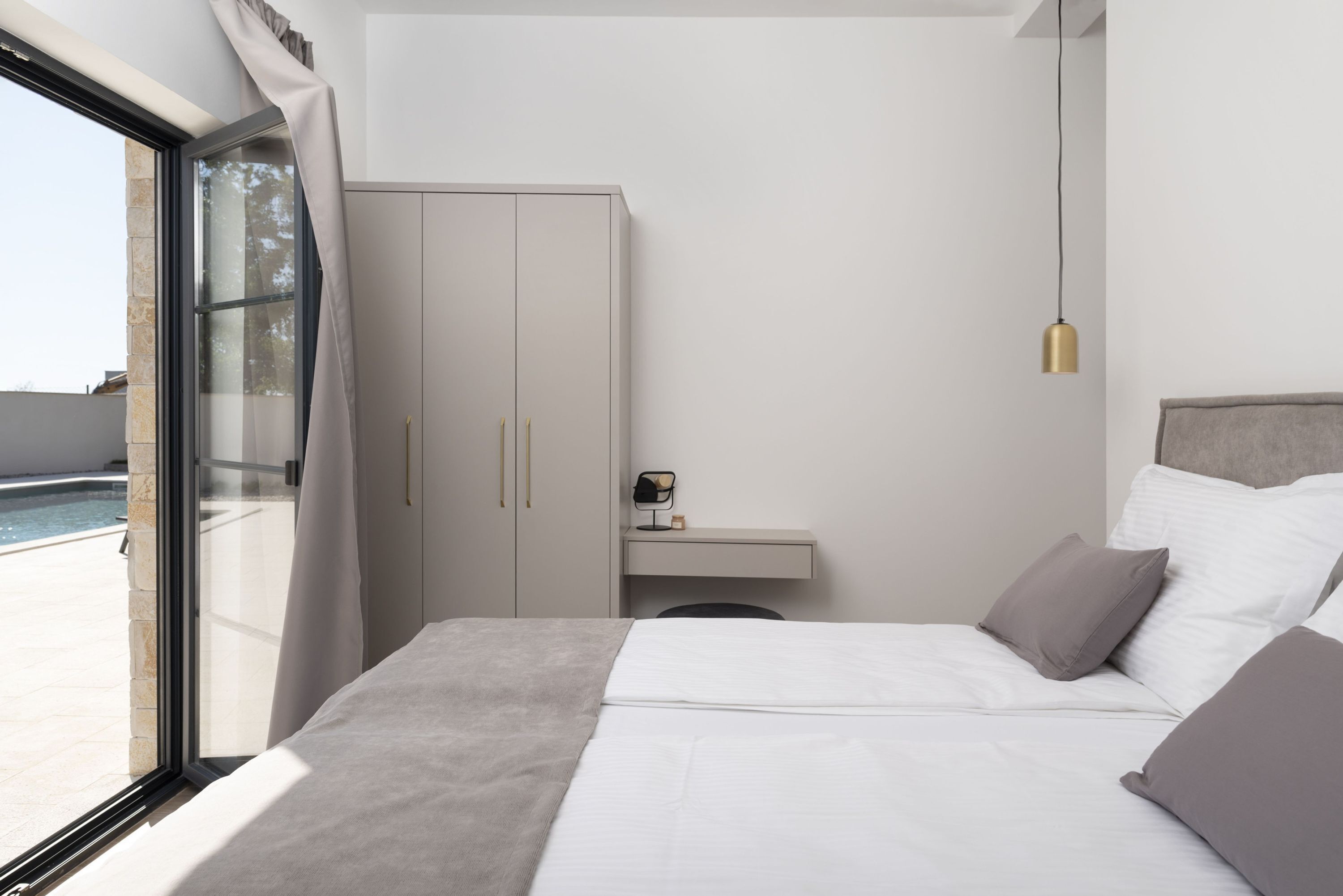 Ein modernes Schlafzimmer mit einem großen Bett, einem Schreibtisch und einem Kleiderschrank.