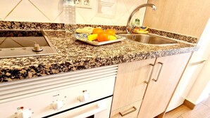 A kitchen with granite countertops, a stainless steel sink, and a built-in oven. - OLYMPIA STUDIO OCEAN VIEW (Playa de las Américas)