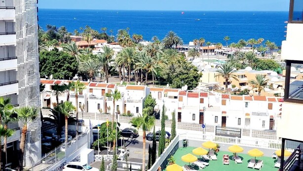 A coastal hotel with multiple balconies overlooking the sea, a rooftop pool area, and a view of the ocean. - OLYMPIA STUDIO OCEAN VIEW (Playa de las Américas)