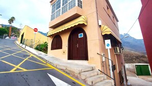 Un bâtiment à la façade jaune, avec un panneau indiquant l’interdiction d’accès et un escalier menant à l’entrée.