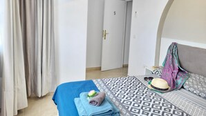 Une chambre à coucher avec un lit, une télévision, un climatiseur et une porte.