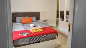 A neatly arranged bedroom with a bed, pillows, a bedside table, and a wardrobe. - Guest House la 7 islas, Red Room (Adeje)