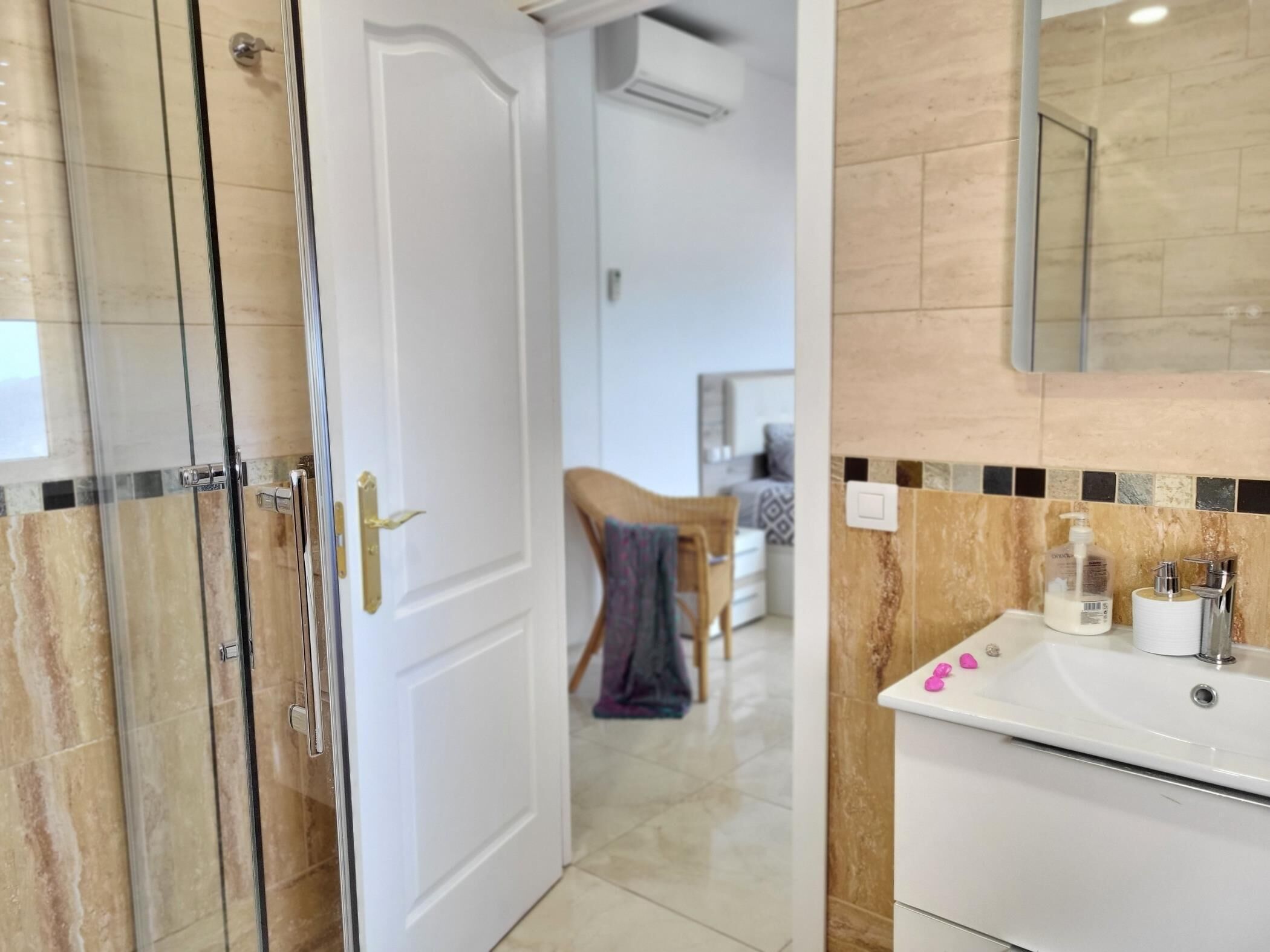 A bathroom with a white sink, a mirror, and a shower area.