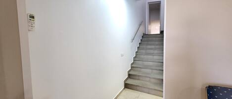 A staircase with a handrail leading to a landing.