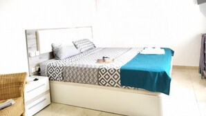 A neatly arranged bedroom with a bed, bedside tables, and a chair. - Guest House Las 7 Islas, White Room Airco (Adeje)