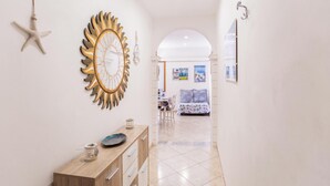 A hallway with a wooden console table, a starfish decoration, and a sunburst mirror. - 3870 Casa del Pescador by Barbarhouse (Vieste)