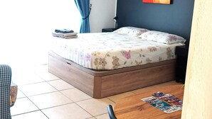 A bedroom with a bed, a nightstand, a lamp, and a painting on the wall. - Mareverde Resort, Blue Studio (Costa Adeje)