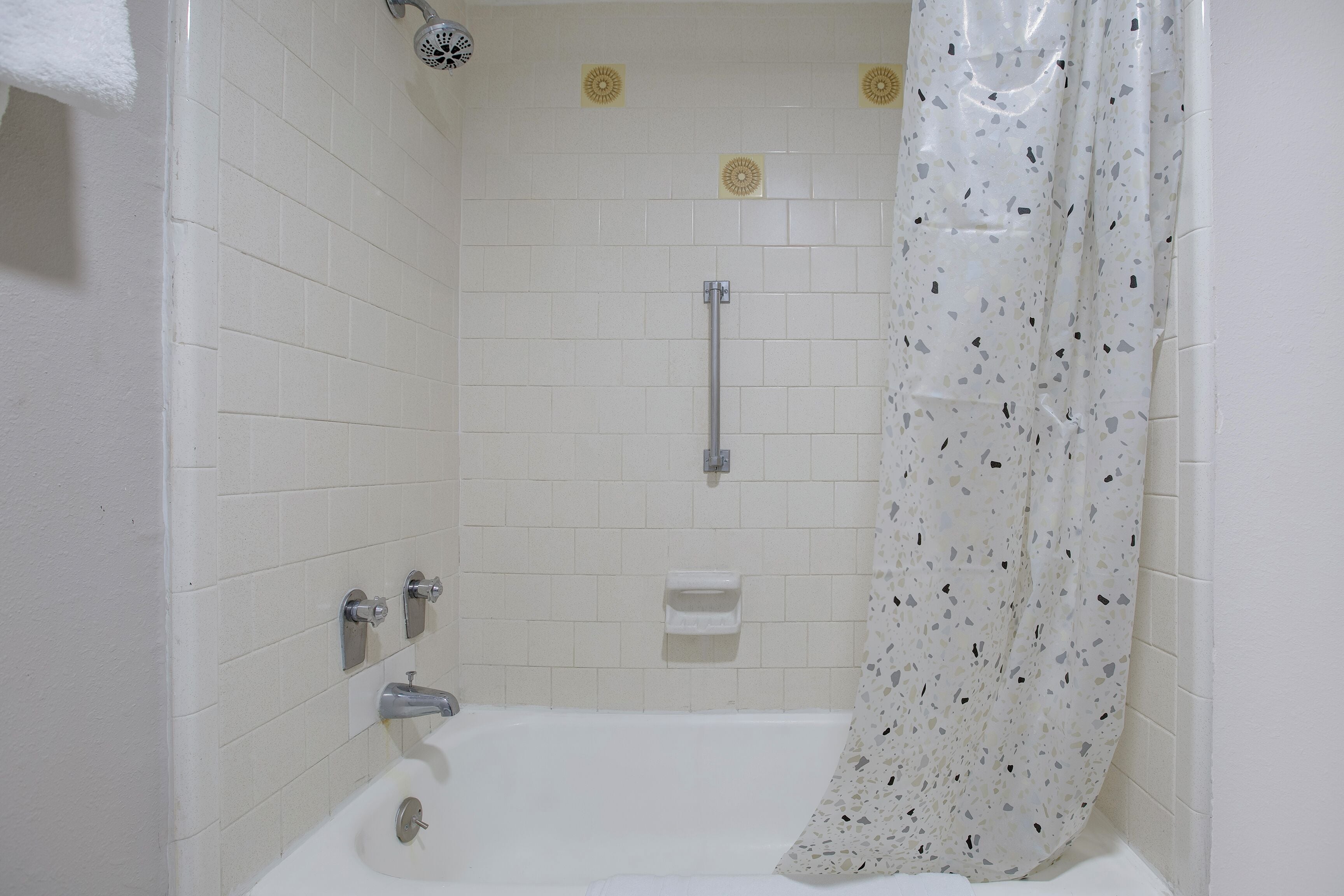 A bathroom with a bathtub, shower, and toilet.