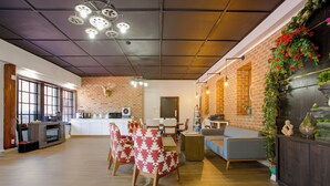 Amplia sala de estar con cocina, comedor y una zona de estar con sillas y sofá.