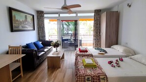 Une chambre d’hôtel avec un canapé, un lit, une table et un balcon offrant une vue.