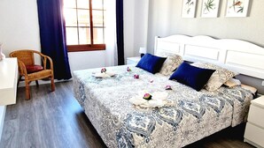 Una habitación de hotel con una cama grande, una silla, un escritorio y una ventana con cortinas.