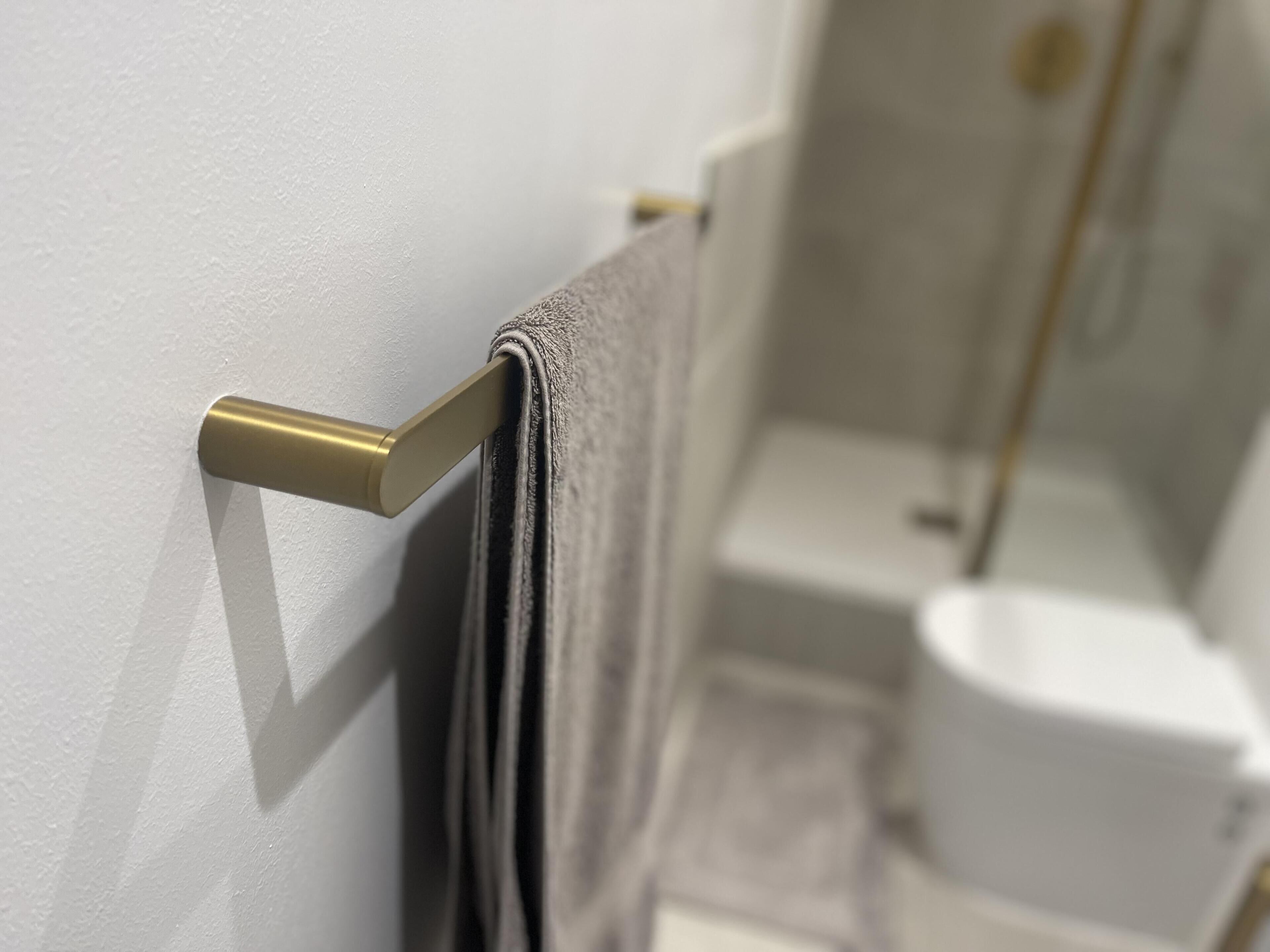 A bathroom with a towel rack, toilet, and shower area.