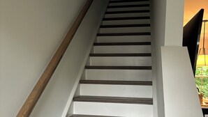 A staircase with white walls and wooden steps.