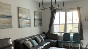 A modern living room with a sectional sofa, a coffee table, and a chandelier.