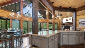 Una cocina amplia con una isla grande, vigas de madera y una chimenea.