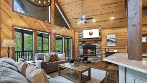 Un salón amplio con chimenea, un conjunto de sofás y una mesa de centro.