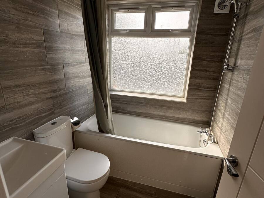 Un baño moderno con bañera, inodoro y ventana.