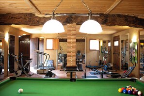 A room with a pool table, exercise equipment, and a brick pillar. - Pretty comfortable holiday home with swimming pool and unique facilities (Lamonzie-Saint-Martin)