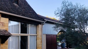 A house with a large sliding glass door, a brick exterior, and a tiled patio area.