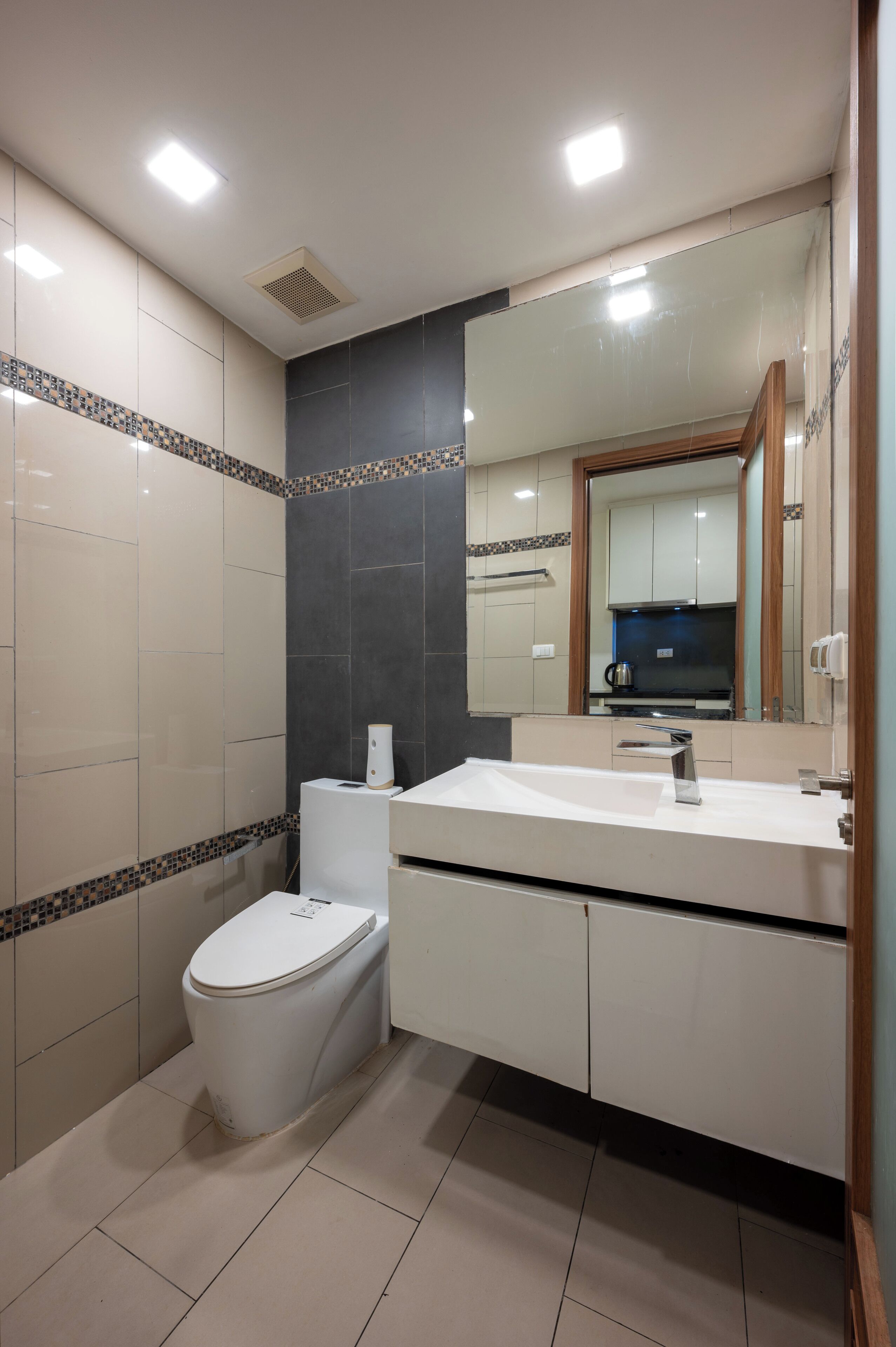 Ein modernes Badezimmer mit Toilette, Waschbecken und Spiegel.