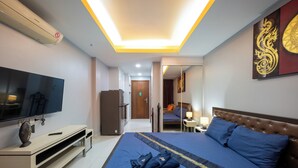Habitación de hotel con cama, televisión y espejo.