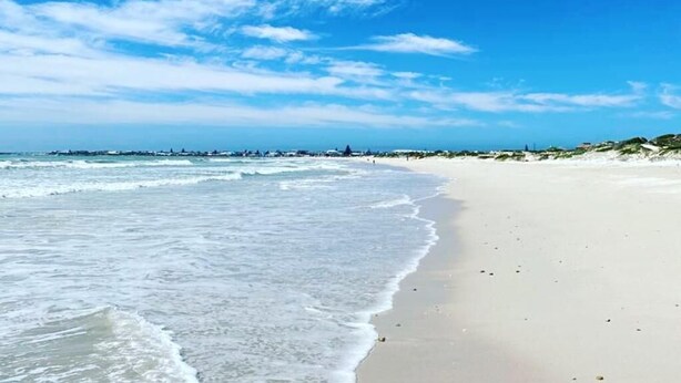A beach with clear skies and gentle waves. - 5 Bedroomed Fisherman's Cottage in Struis Bay (Struisbaai)