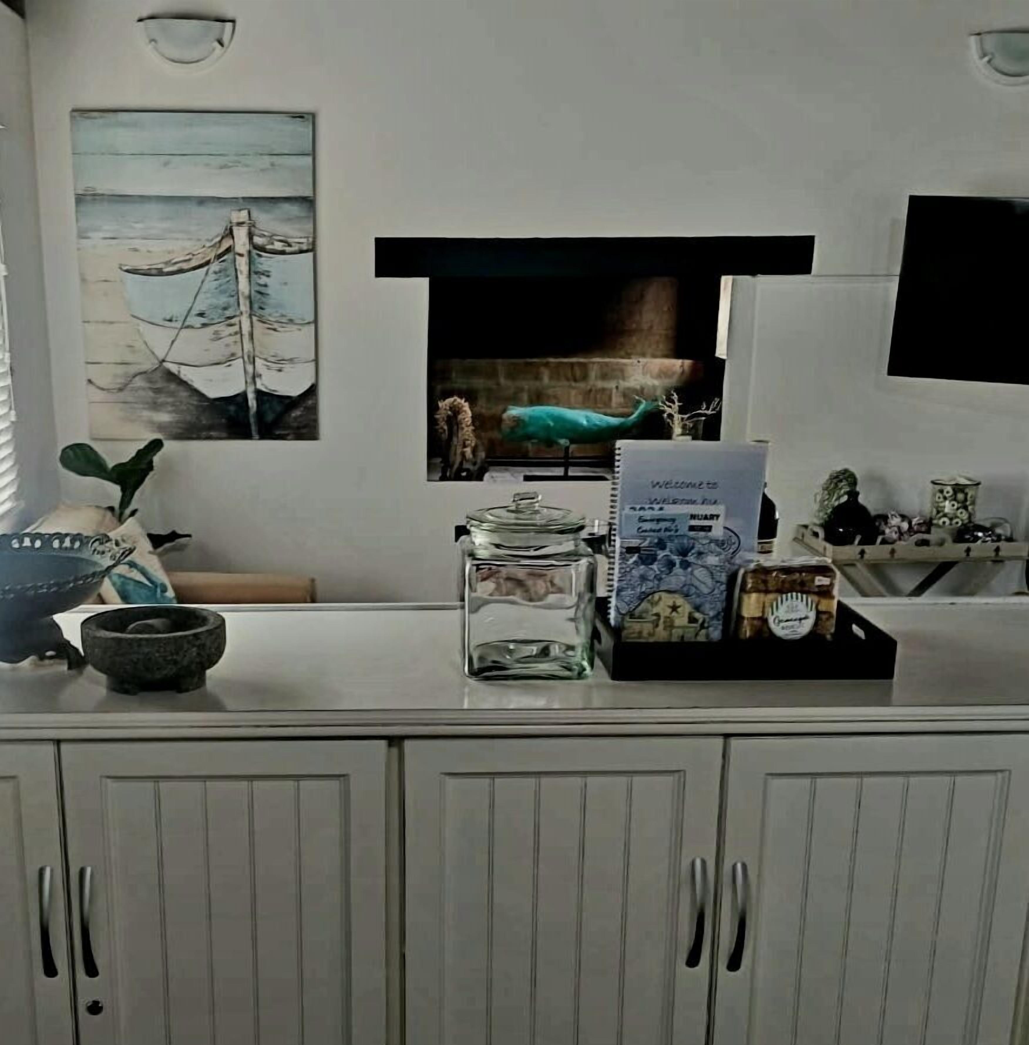 A reception area with a counter displaying a welcome sign, a decorative vase, and a small plant.