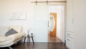 Een moderne woonkamer met een bank, een klein bijzettafeltje en een glazen salontafel.