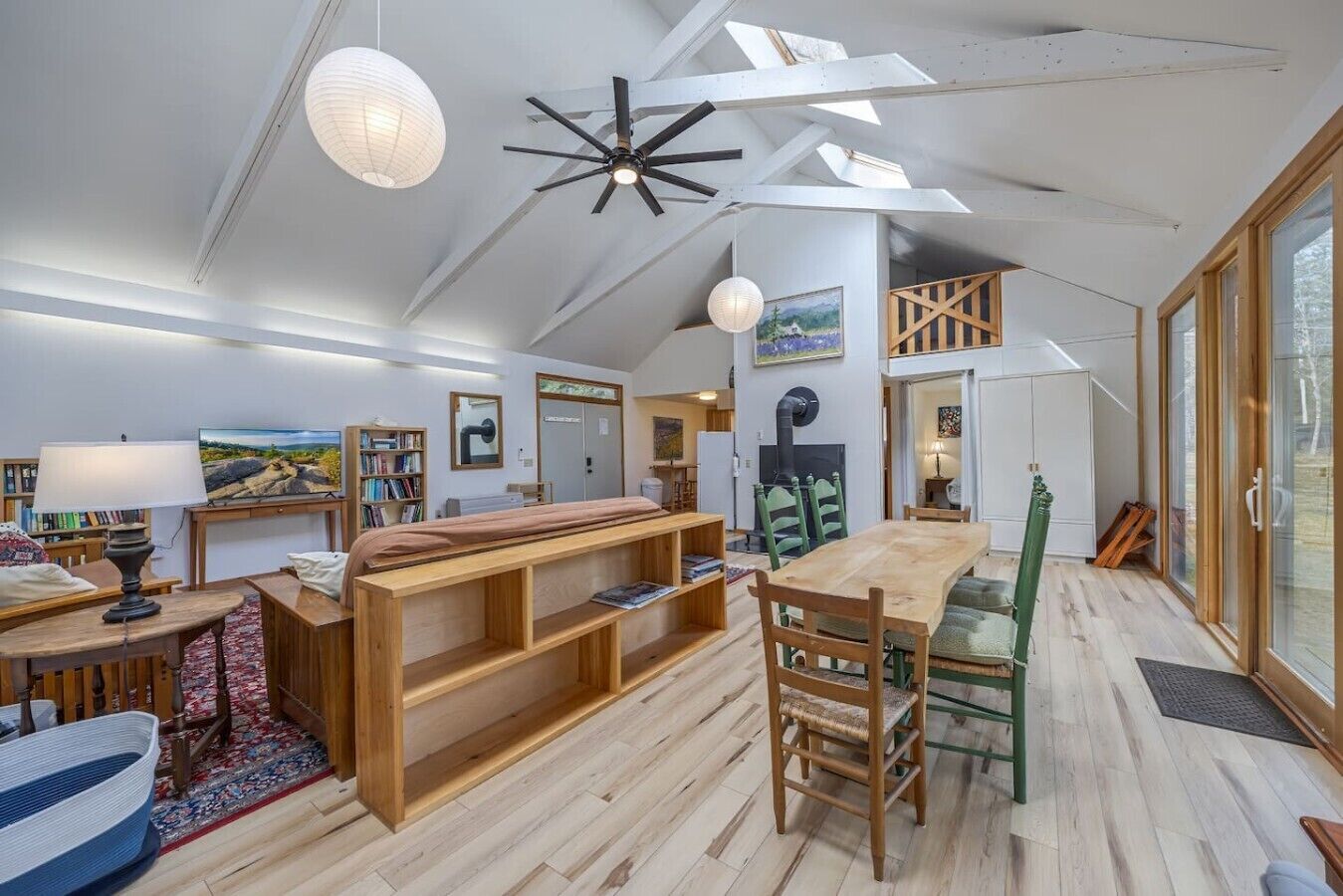 Spazioso loft con soffitto alto, zona pranzo, una panca integrata e un'ampia finestra con vista.