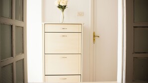 A white cabinet with three drawers and a vase with white flowers on top.
