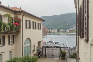 A riverside view with a boat docked near a building with a balcony. - Filanda - Best Lakefront in Como (Como)