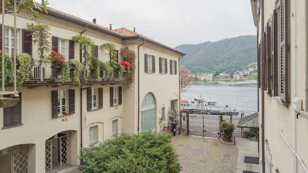 A narrow courtyard with a view of a river and hills in the background. - Filanda - Best Lakefront in Como (Como)