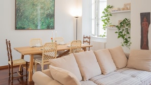 A dining area with a wooden table and chairs, a sofa, and a painting on the wall. - Filanda - Best Lakefront in Como (Como)