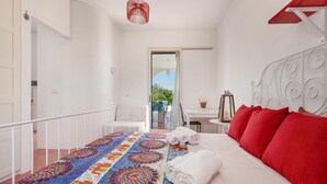 A bedroom with a bed, a colorful rug, a red headboard, and a view of the outdoors. - 3880 Villa Sierri by Perle di Puglia (Carovigno)
