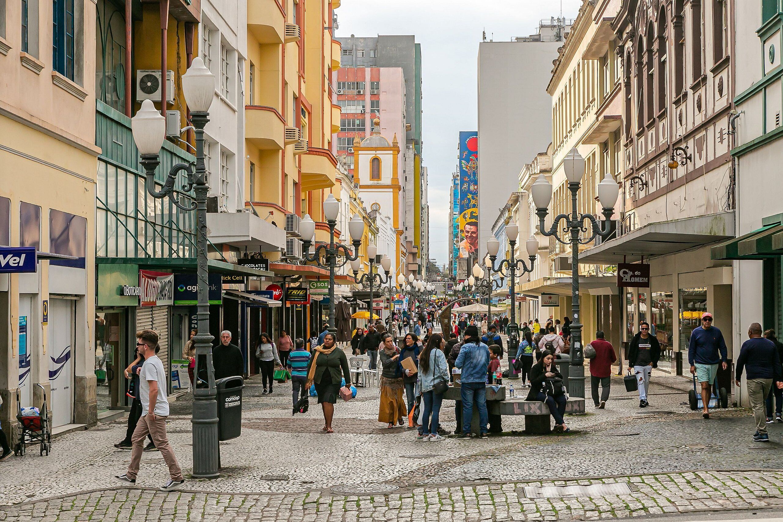 A bustling street scene with pedestrians, shops, and buildings.