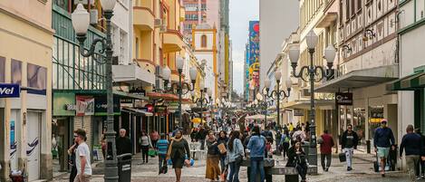 A bustling street scene with pedestrians, shops, and buildings.