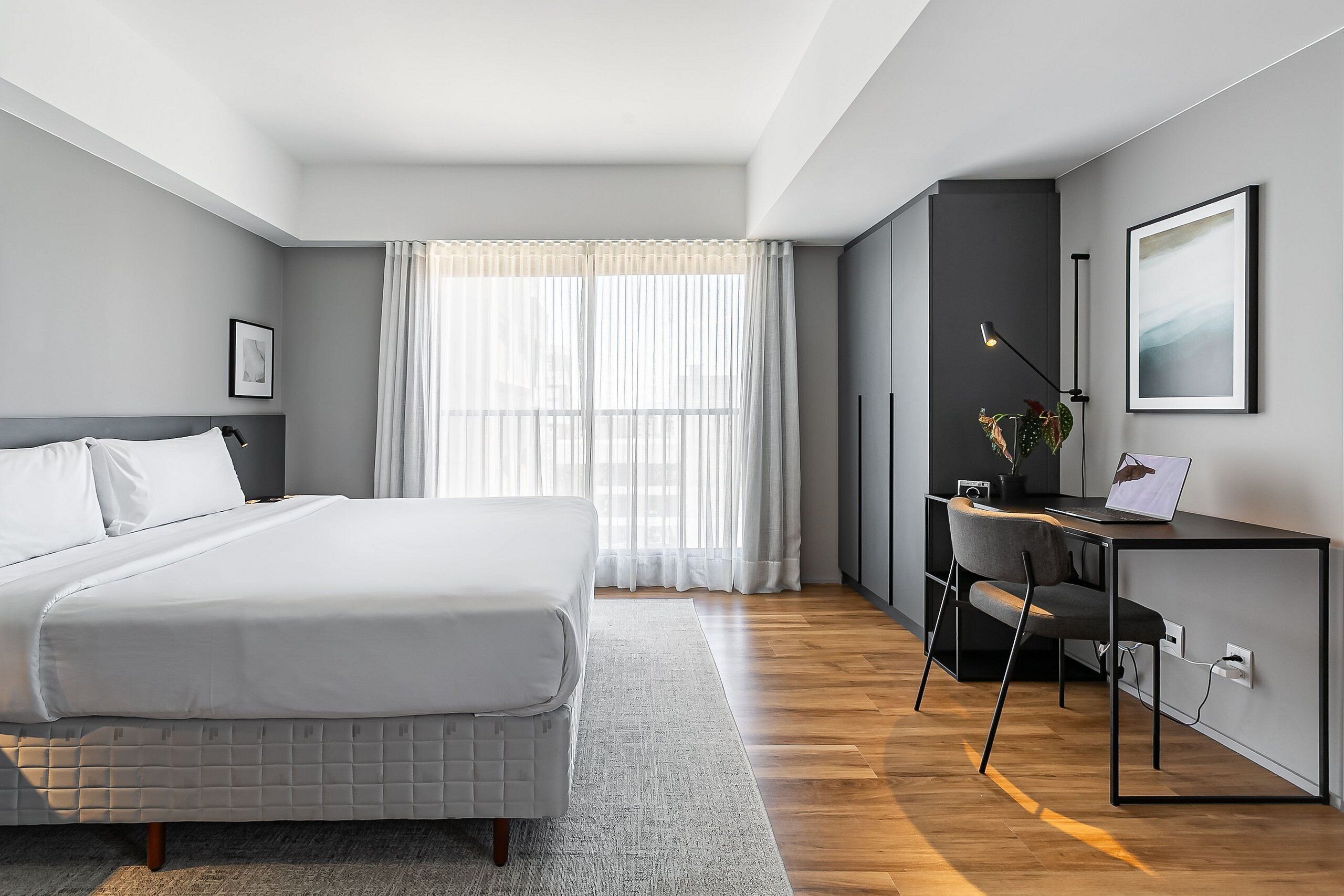 A modern bedroom with a bed, a desk, and a chair.