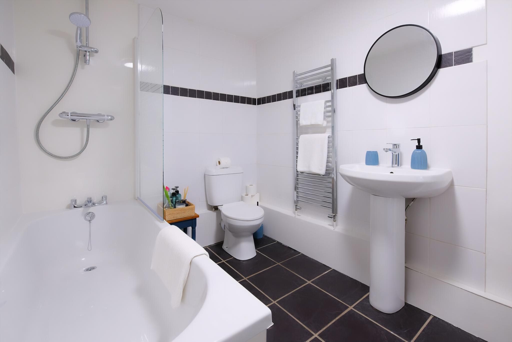 A bathroom with a bathtub, toilet, sink, and shower.