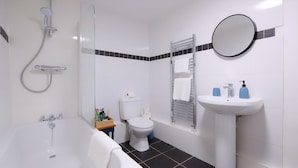 A bathroom with a bathtub, toilet, sink, and shower. - 3 Bed Home near Hiking Trails & Parks (Rhondda)