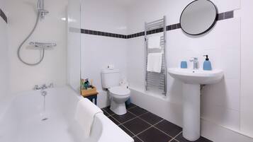 A bathroom with a bathtub, toilet, sink, and shower.