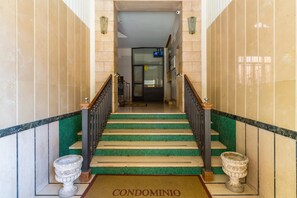 Eine Treppe mit grünen Stufen, die zu einer Tür mit der Aufschrift 'CONDOMINIO' führt.